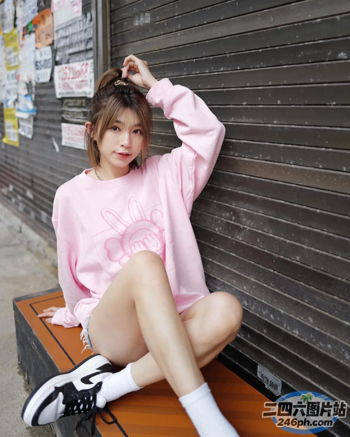 坐在墙前长凳上的阿拉菲德女人