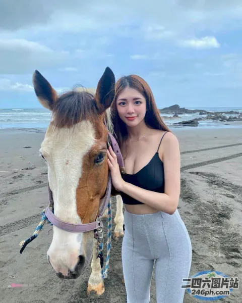 一名女子站在海滩上的一匹马旁边