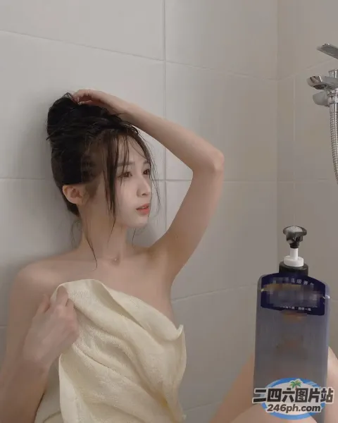穿着毛巾坐在浴缸里拿着一瓶洗发水的 arafed 女人