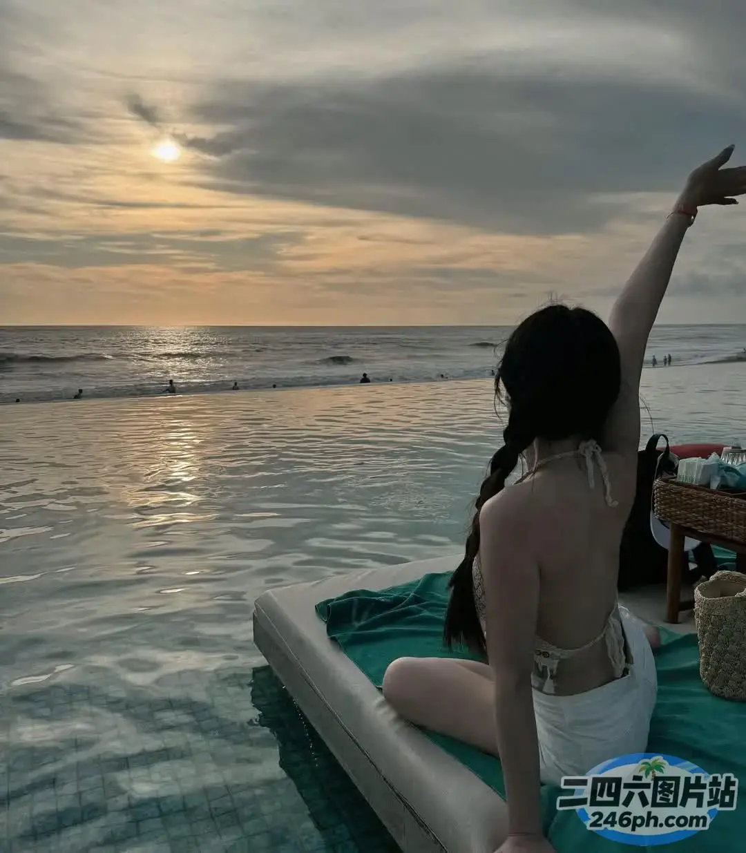 海滩上有一个女人坐在毯子上