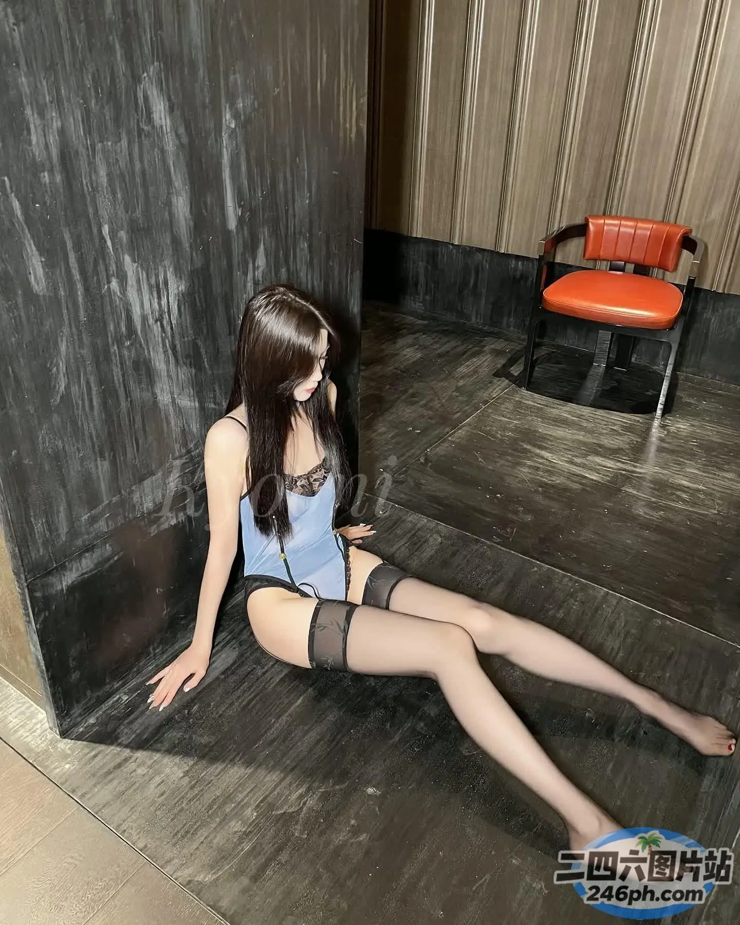 穿着蓝色上衣和黑色丝袜坐在地板上的阿拉夫德女人