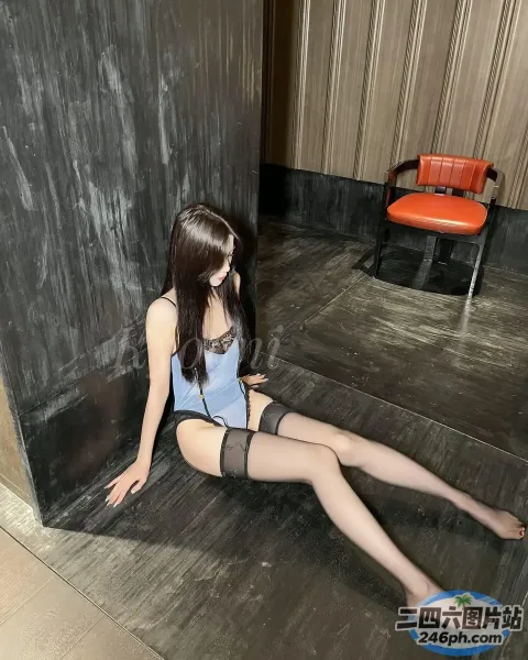 穿着蓝色上衣和黑色丝袜坐在地板上的阿拉夫德女人