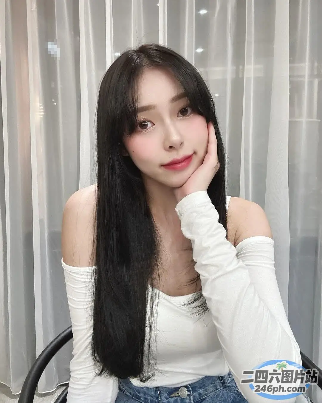一位黑长发女子坐在桌子旁的特写