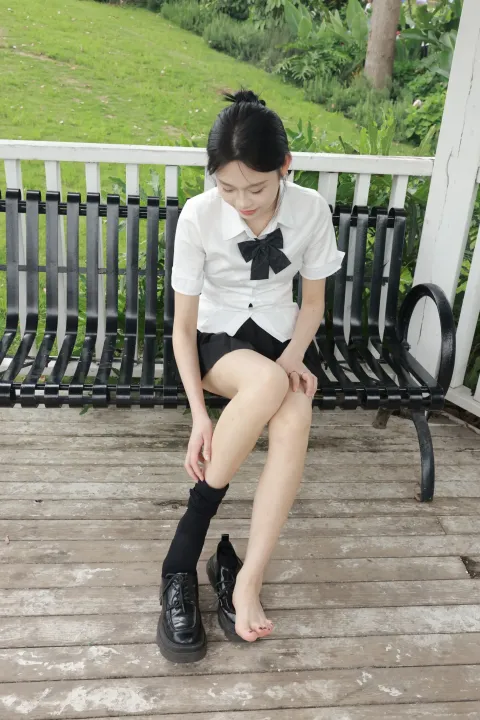 有个女人坐在长凳上，双腿交叉