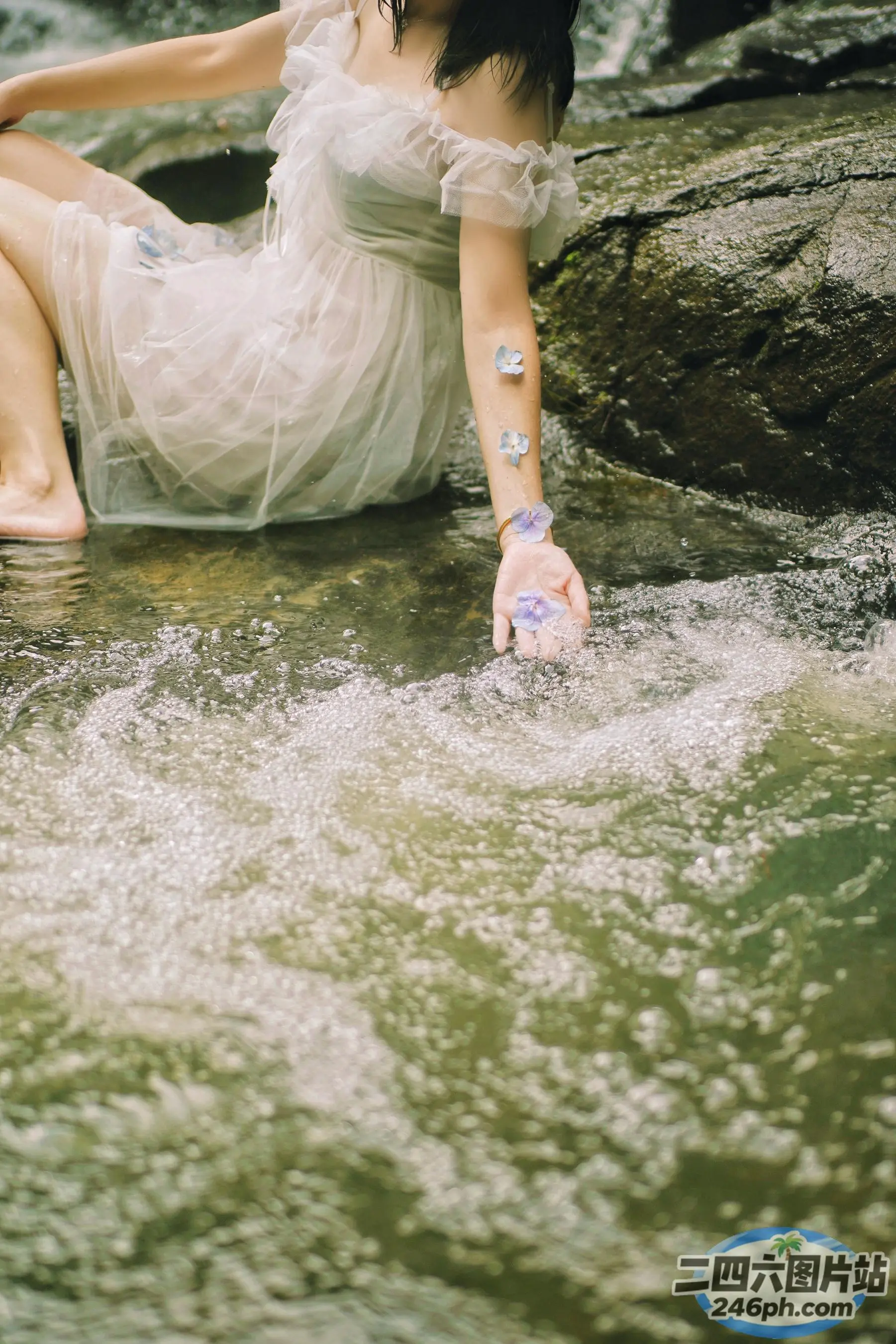 There is a woman on a rock in the water （有个女人坐在水中的一块岩石上）