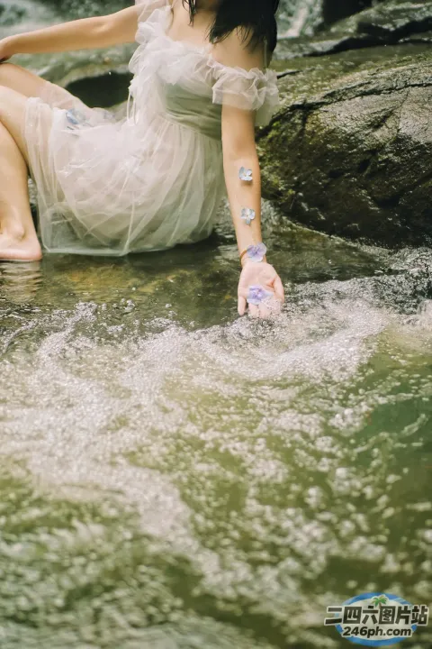 There is a woman on a rock in the water （有个女人坐在水中的一块岩石上）