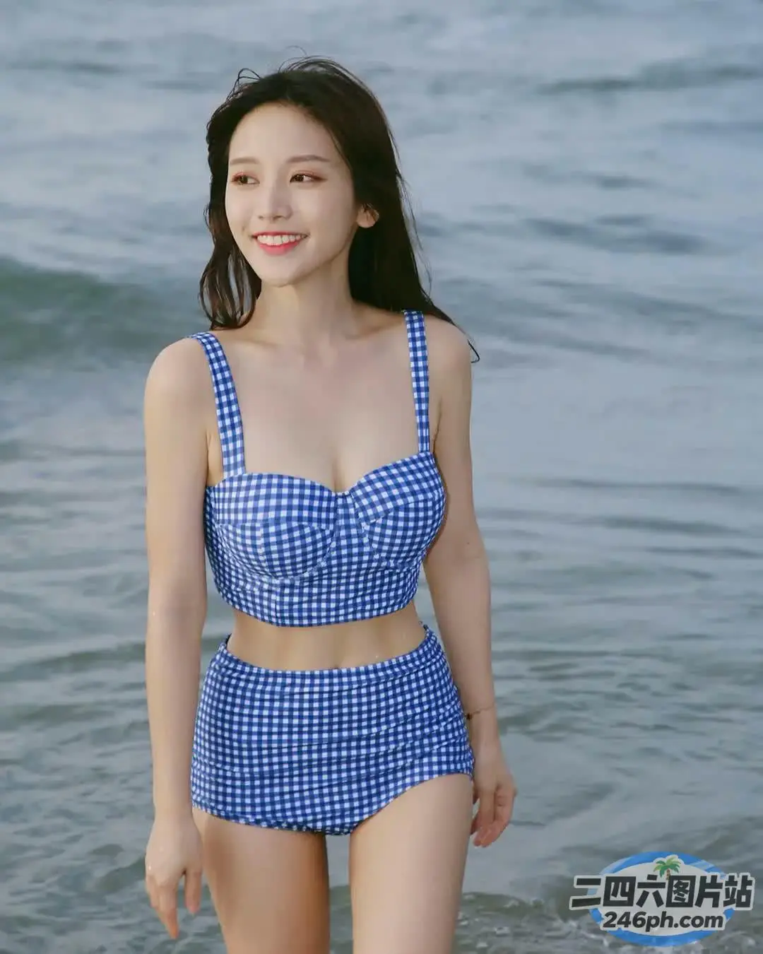 身穿蓝白比基尼的 araffe 女人站在海里