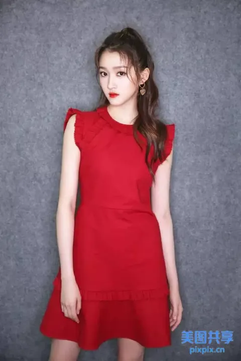 一位身穿红色连衣裙的女子摆姿势拍照