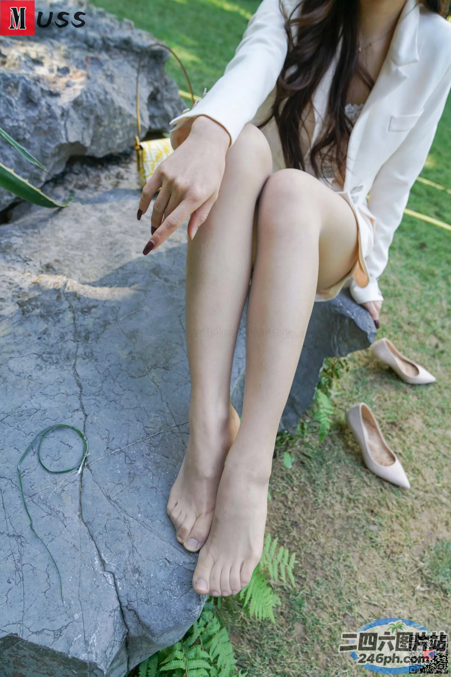 双腿交叉坐在岩石上的 Araffed 女人