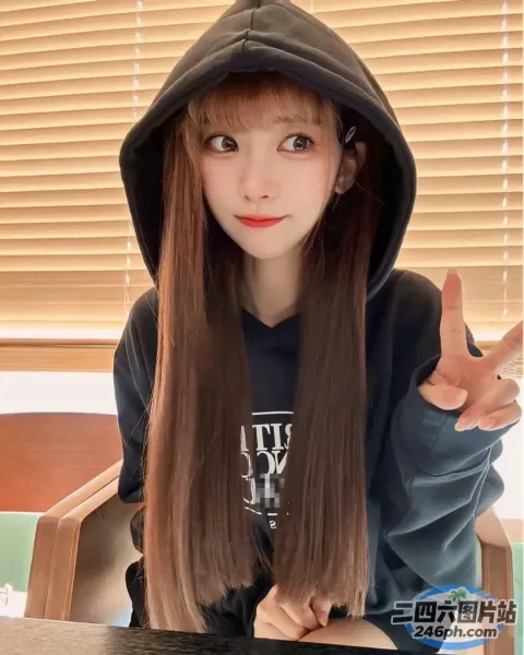 棕色长发的 arafed 女孩，穿着连帽衫，指着镜头