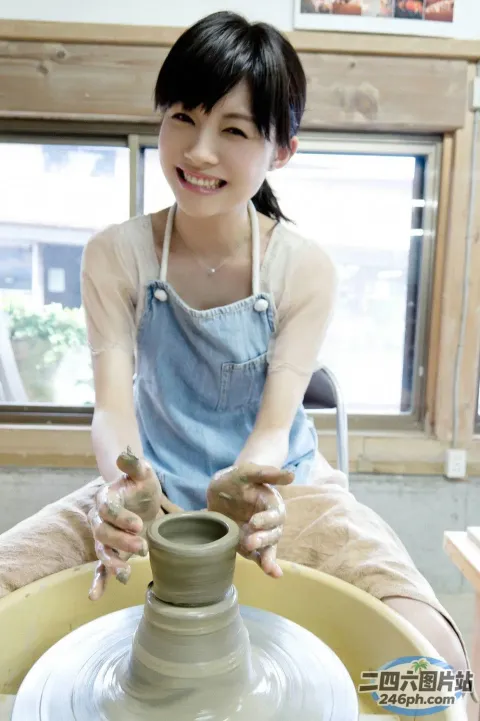 身穿蓝色连衣裙的 Arafed 女子正在轮子上制作花盆
