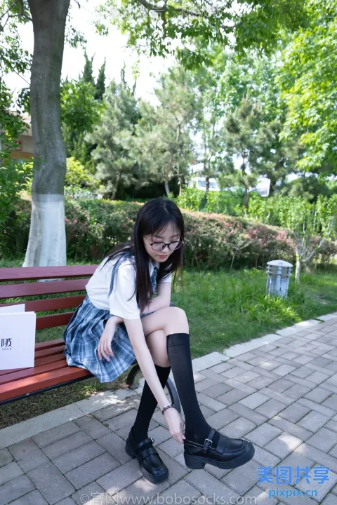 arafed 亚洲女孩坐在长凳上，上面有个标志