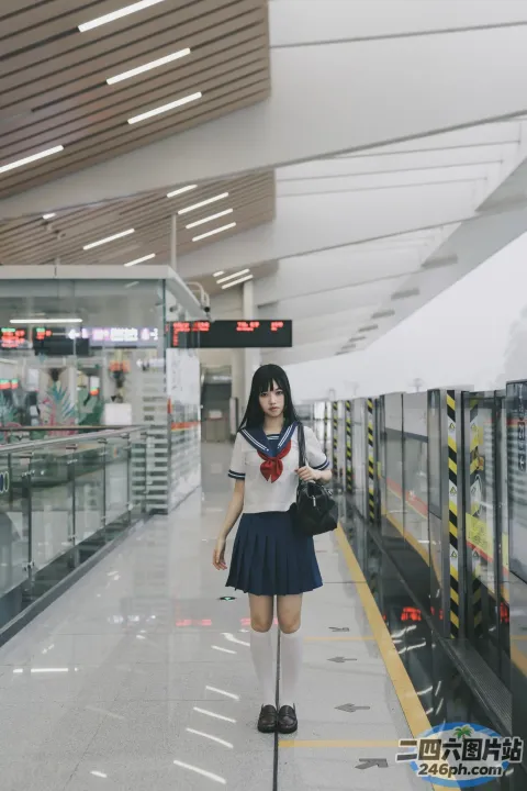 火车站里站着一个女人，手里拿着一个袋子