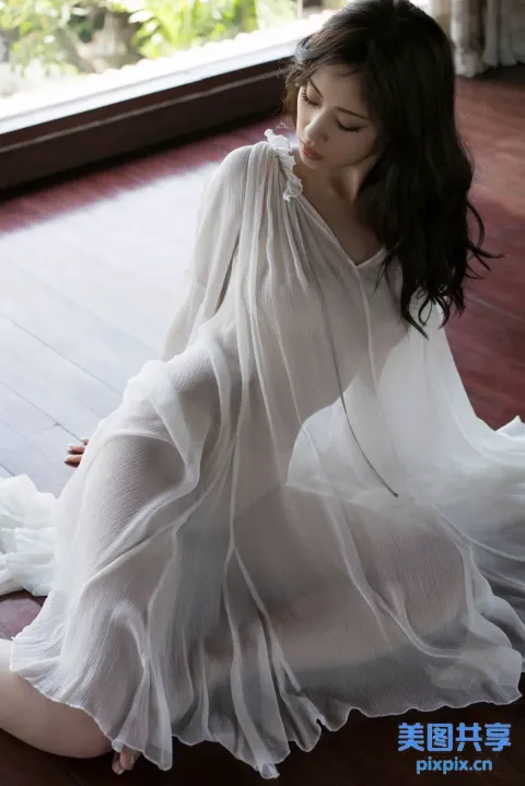 坐在木地板上、身穿白色连衣裙的阿拉夫德女人