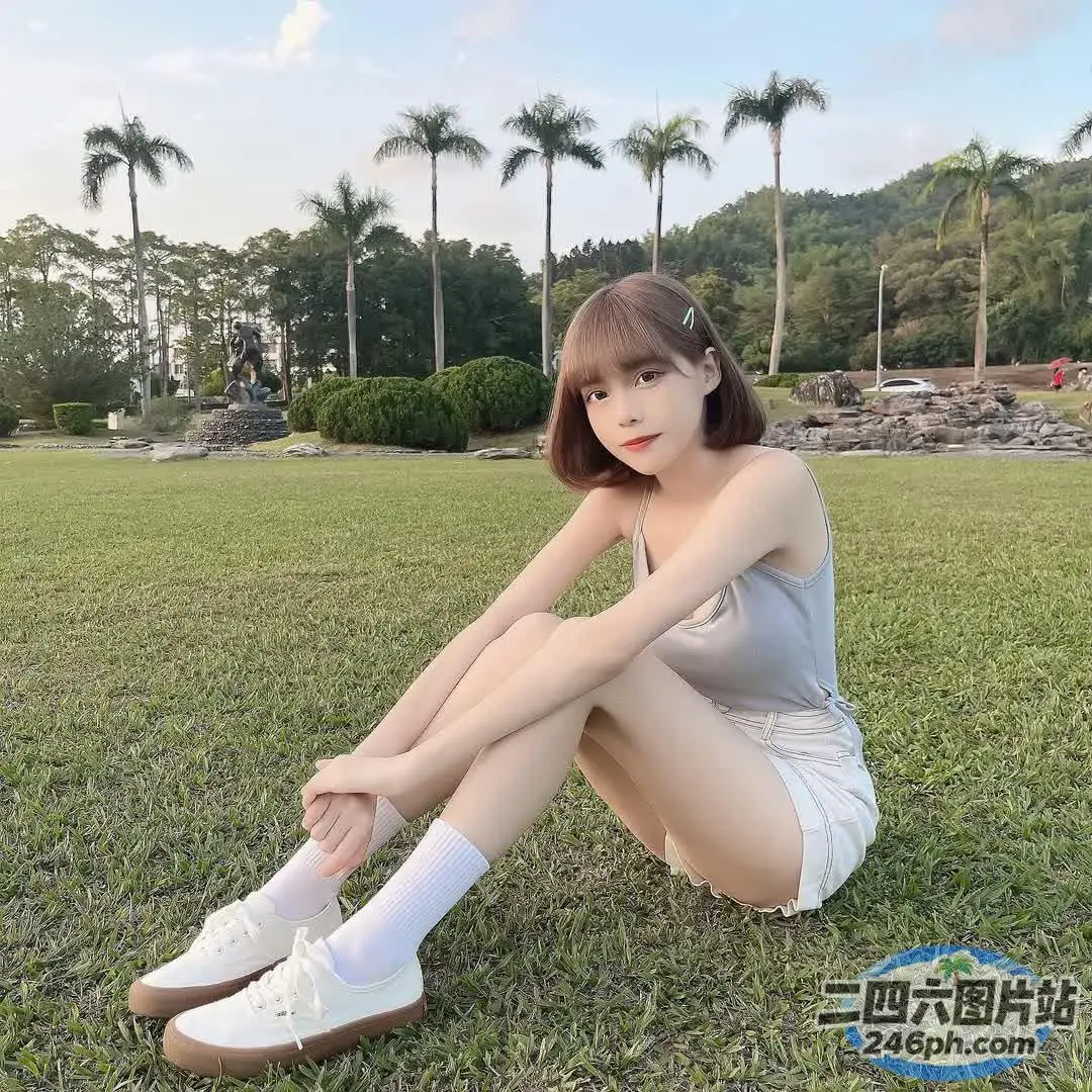 一名女子盘腿坐在公园的草地上