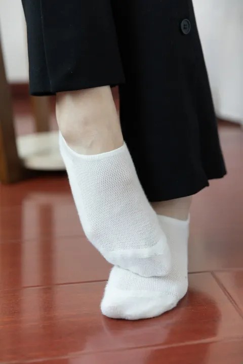 一个穿着白色袜子和黑色裤子的人的特写