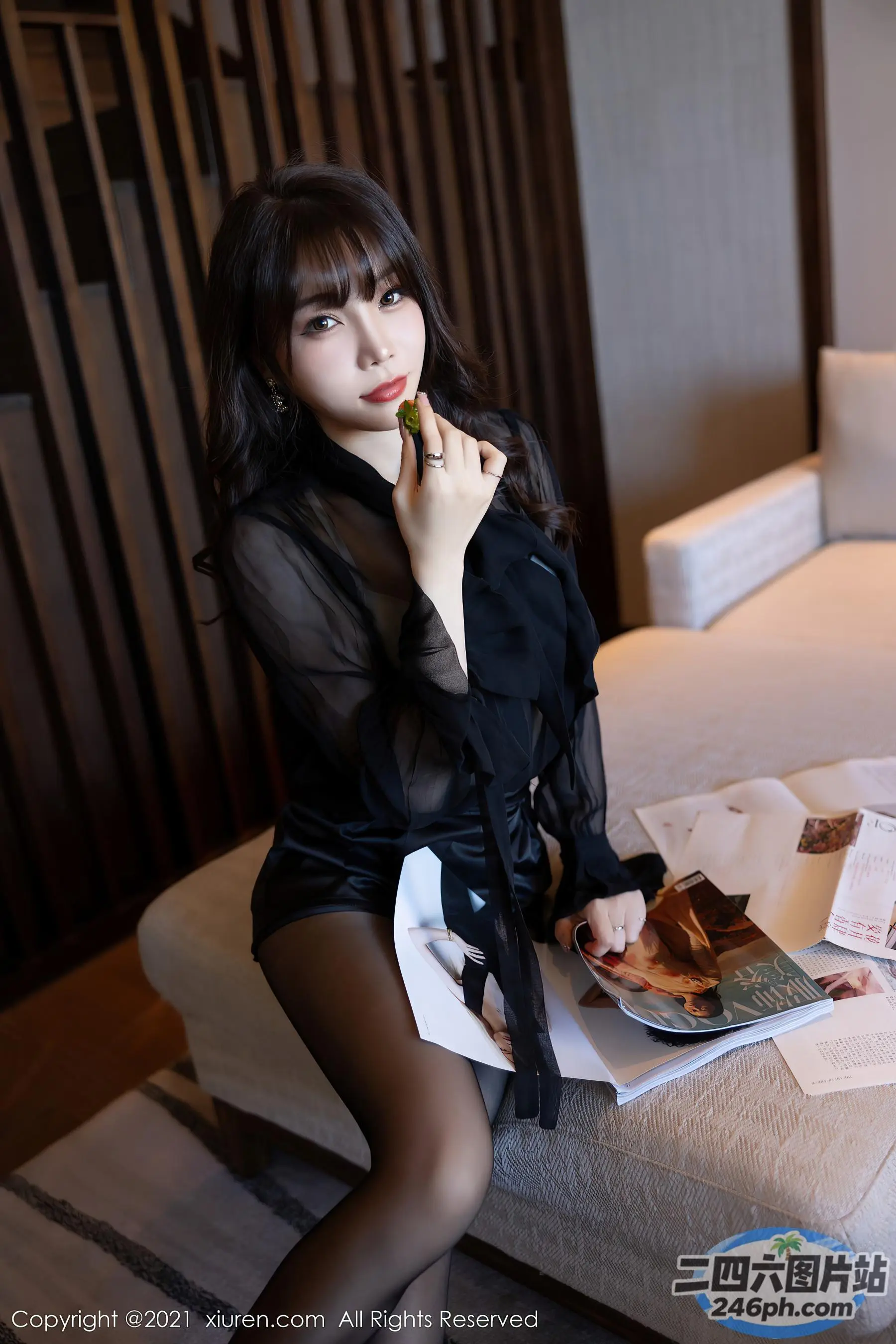 床上坐着一个女人，手里拿着一本杂志