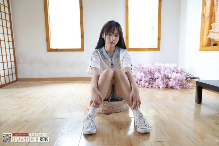 坐在房间木地板上的 arafed 亚洲女子