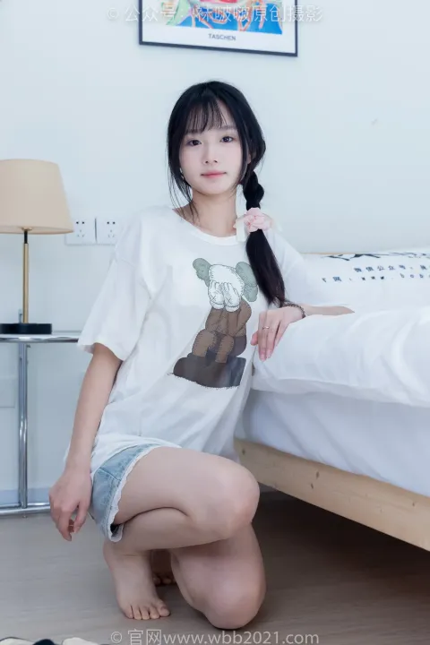 一个女人穿着白衬衫跪在床上的特写