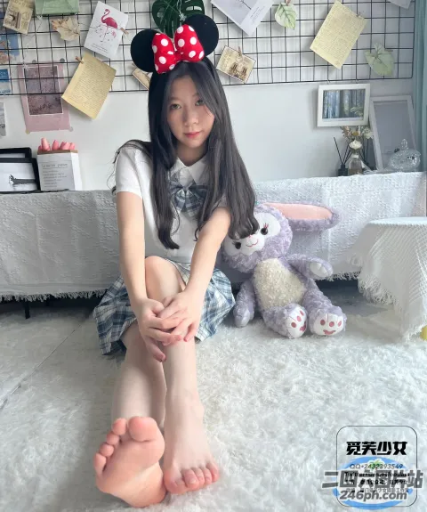 有一个年轻的女孩坐在地板上，双叉