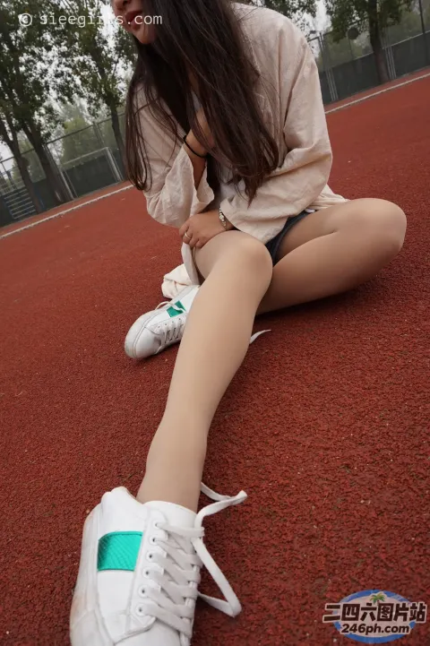 阿拉菲坐在地上，双腿交叉，穿着鞋子