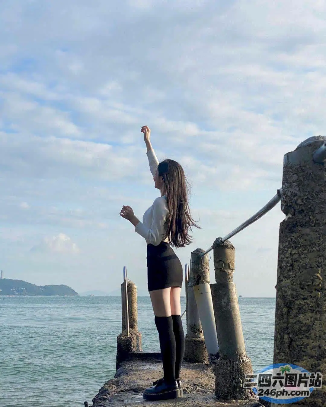 有个女人站在码头上，双臂高举