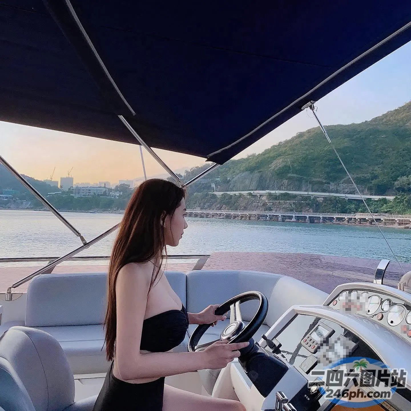 身穿黑色连衣裙的 Arafed 女子在湖上驾船