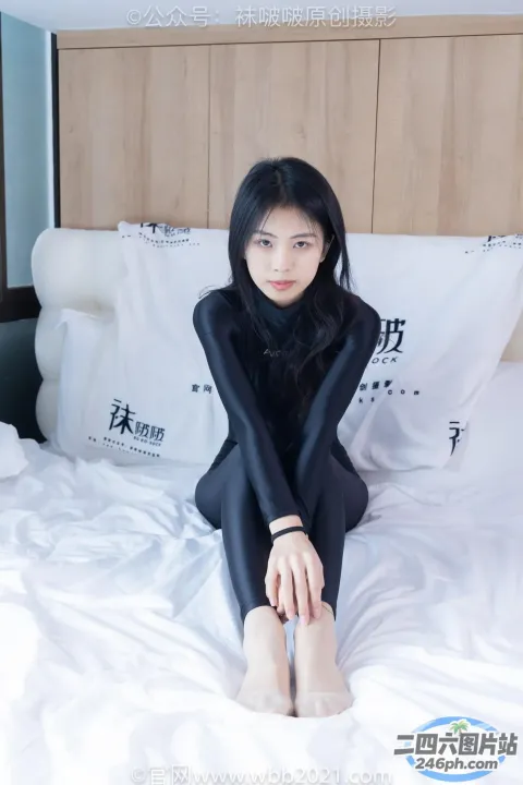 坐在床上穿着黑色潜水服的 Arafed 女人