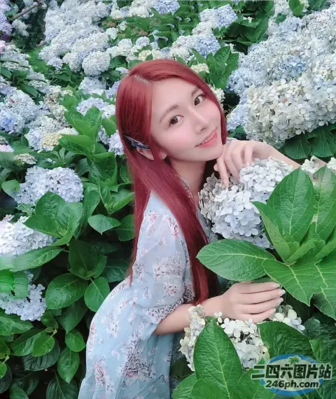 红发女子在花丛前摆姿势