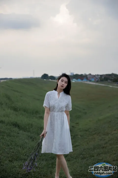 有个女人走在田野里，手里开满了一束花