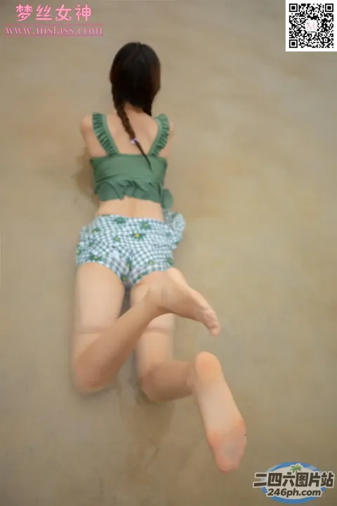 穿着绿色上衣和蓝色短裤躺在地上的阿拉夫德女人