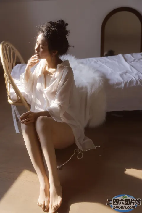 床上坐着一个穿着白色长袍的女人