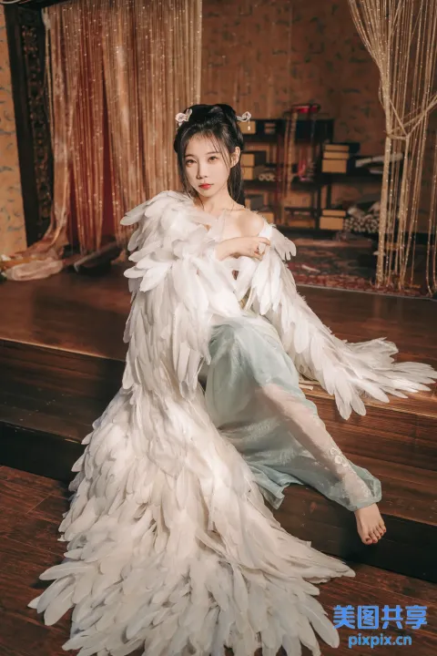 坐在木地板上，身穿白色连衣裙的阿拉夫德女人