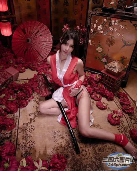 穿着红色连衣裙的 Arafed 女人坐在地毯上，手里撑着一把红伞