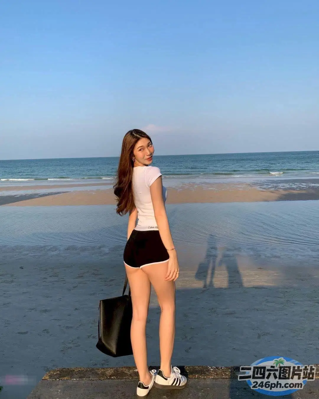有一个女人站在混凝土平台上，望着大海