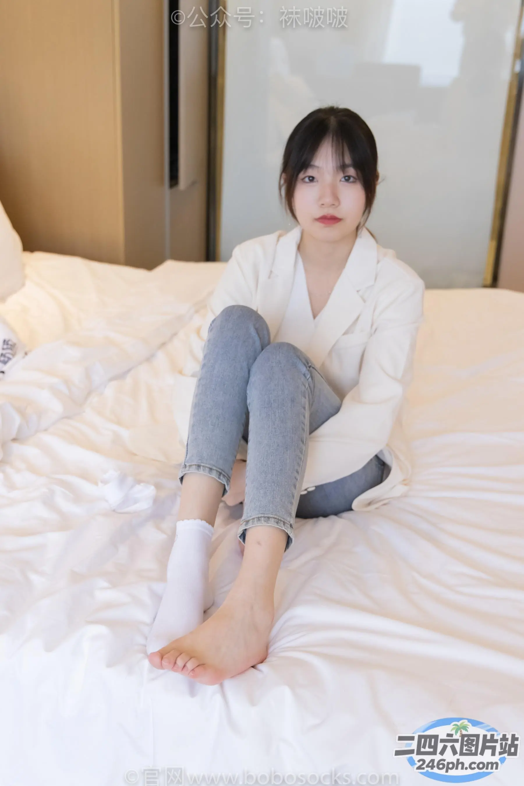 Araffe 坐在床上，穿着白色夹克和牛仔裤