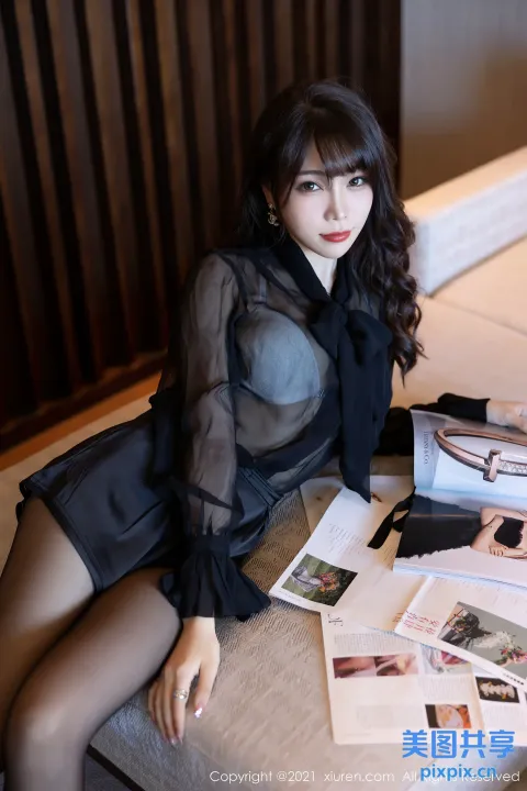 床上坐着一个女人，手里拿着一本杂志