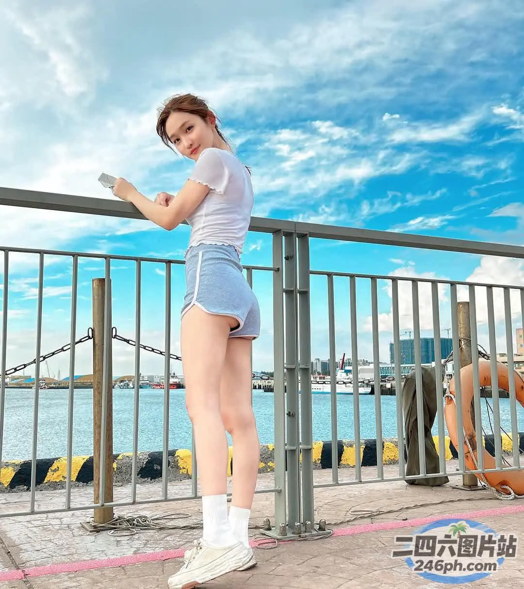 有个女人站在码头上看手机