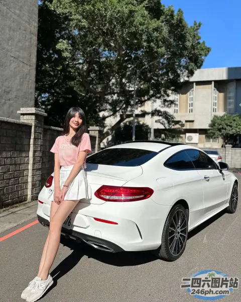 阿拉菲在城市街道上的一辆白色汽车旁摆姿势