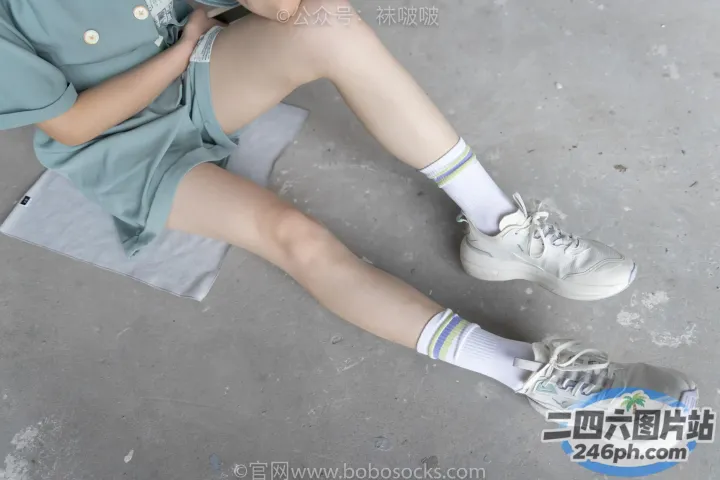 穿着蓝色连衣裙和白色运动鞋的 araffe 女孩坐在毛巾上