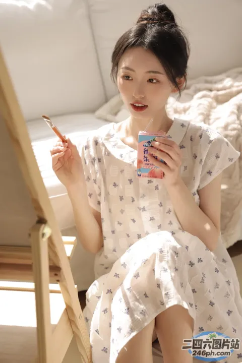 床上坐着一个女人，手里拿着杯子和香烟