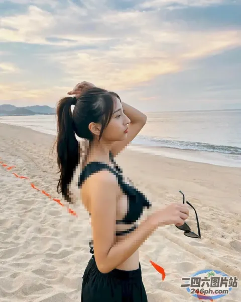 有一个女人站在海滩上，手里拿着风筝