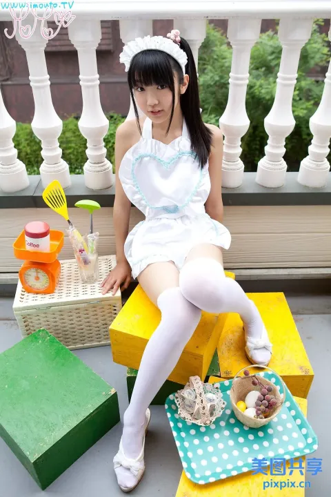坐在长凳上的白裙亚洲女孩
