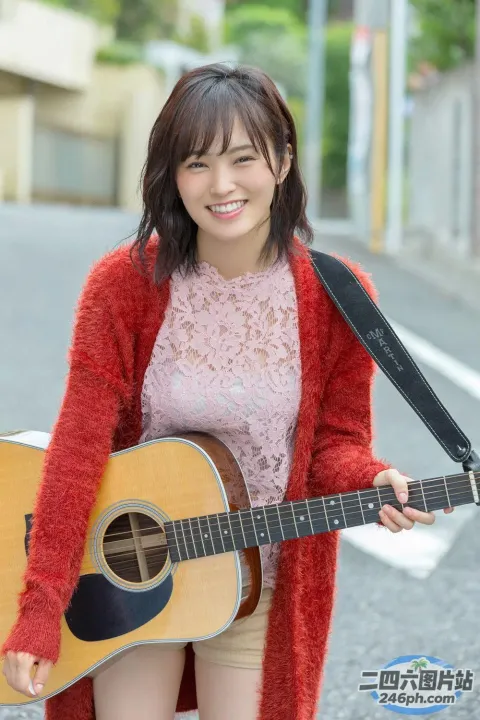 站在街上，阿拉费德女子拿着吉他面带微笑