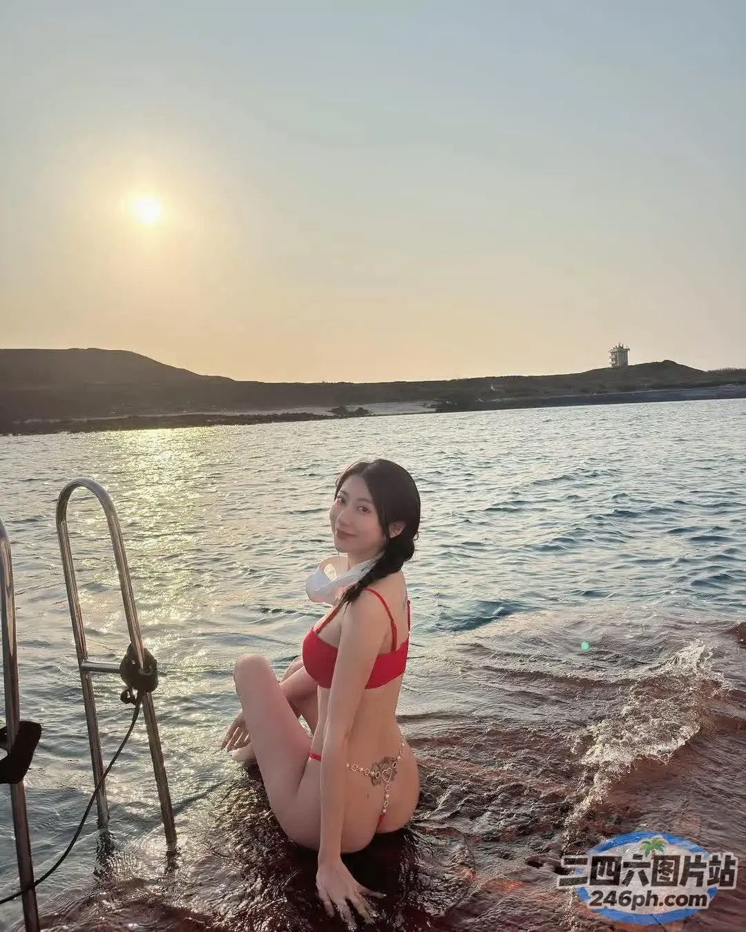 穿着红色比基尼的 arafed 女人坐在水中的船上