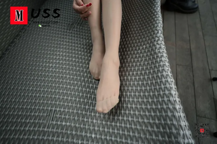 有个女人坐在长凳上，双腿交叉