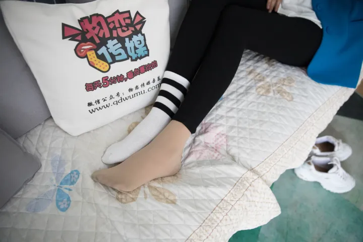 有个女人坐在床上，手里拿着一个枕头