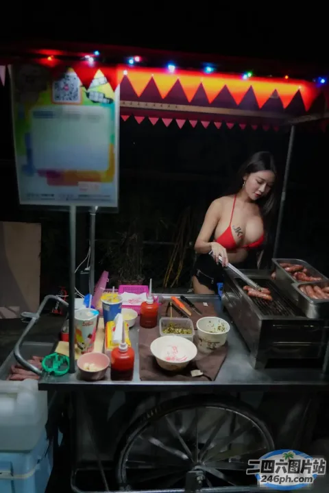 有个女人在街边小贩的烤架上烤热狗