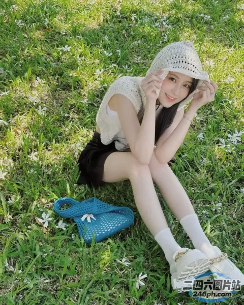 戴着帽子坐在草地上的 Araffe 女孩