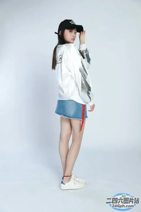 身穿白色夹克和蓝色裙子的阿拉夫女子摆姿势拍照